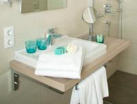 a bathroom sink with two blue glasses on it at Hotel Claro Garni in Eitting