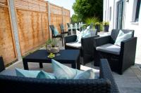 a group of chairs and tables on a patio at Hotel Claro Garni in Eitting