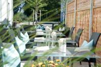 a row of tables and chairs on a patio at Hotel Claro Garni in Eitting