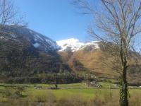 a snow covered mountain in a field with a tree at Lo Saunei in Laruns