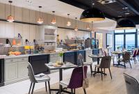 Un restaurante con mesas y sillas en una cocina. en Hôtel la Baie Valdys Resort & SPA, en Douarnenez