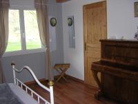 a bedroom with a bed and a piano and a window at Lo Saunei in Laruns