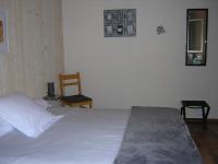 a bedroom with a white bed and a chair at Lo Saunei in Laruns