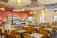 Un comedor con mesas y sillas amarillas. en SOWELL Family Riviera, en Saint-Raphaël