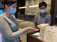 a woman wearing a mask standing next to a man with a machine at Platinum Hotel in Xindian