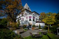 a large white building with a pointed roof at Bagatelle Gardenhouse in Budapest
