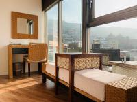 a room with a table and chairs and a large window at Chiu Chunt Dint B&amp;B in Jiufen