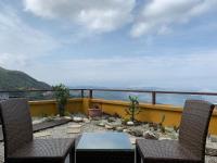 a patio with two chairs and a table on a balcony at Chiu Chunt Dint B&amp;B in Jiufen