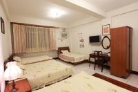 a bedroom with two beds and a desk and a television at Lily House in Ji&#39;an