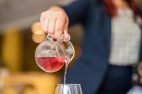 a person is pouring wine into a wine glass at Hotel am Schloß Apolda in Apolda