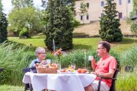 two men sitting at a table with food and drinks at Hotel am Schloß Apolda in Apolda