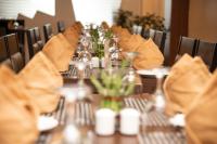 a long table with chairs and a table set for a meal at Hotel Ballerina in Tinsukia