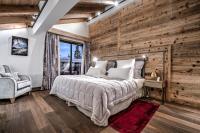 a bedroom with a bed and a wooden wall at Hôtel La Sivolière in Courchevel