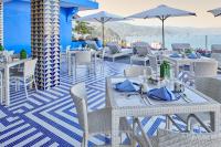 Un restaurante con mesas y sillas blancas en un patio. en Hotel Luxury Patio Azul, en Puerto Vallarta