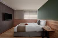a bedroom with a large bed and a television at Muzik Hotel - Ximen Station Branch in Taipei