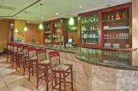 een bar met een rij krukken in een restaurant bij Holiday Inn Bloomington-University Area by IHG in Bloomington