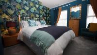 Un dormitorio con una cama grande con paredes azules. en Moryn. Snowdonia and Anglesey View, en Bangor