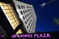un edificio alto con una señal rosa delante de él en Crowne Plaza Bursa Convention Center & Thermal Spa by IHG, en Bursa
