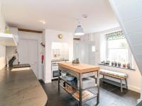 a kitchen with a wooden table in a room at 1 Jubilee Cottage in Tintagel