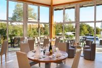Un restaurante con mesas, sillas y ventanas. en Logis Hôtel Val de Vienne, en Le Vigeant