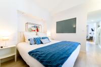 a bedroom with a large bed with a blue blanket at Hôtel La Jetée in Saint-Martin-de-Ré