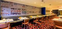 un restaurante con una fila de mesas y sillas en Holiday Inn Leeds Garforth by IHG, en Garforth