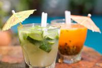 two drinks sitting on a table with umbrellas at Pousada Arte Urquijo in Paraty
