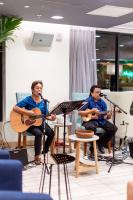 two men sitting in chairs playing guitars andmusic at VIVE Hotel Waikiki in Honolulu