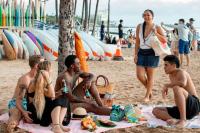 a group of people sitting on the beach at VIVE Hotel Waikiki in Honolulu