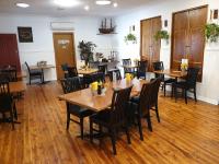 uma sala de jantar com mesas e cadeiras de madeira em Best Western Endeavour Motel em Maitland