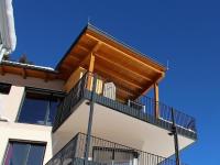 a building with a balcony with a wooden roof at Penthouse Skyview im Natur-Erlebnispark Bad Kleinkirchheim in Patergassen
