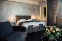 a bedroom with a large bed and a couch at Amirauté in La Baule