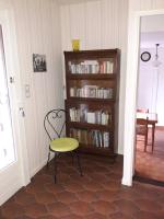 a room with a chair and a book shelf with books at VILLA LA LURETTE, appartement et studio in Saint-Étienne-les-Orgues