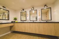 a bathroom with three sinks and two mirrors at Ahiruyah Guesthouse in Kaohsiung