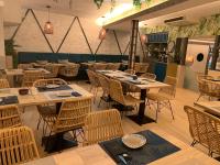 Un restaurante con mesas y sillas en una sala. en Hostal Real Aranjuez, en Aranjuez