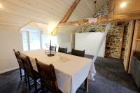 a dining room with a table and chairs and a whiteboard at Le Logis de Mordreuc in Pleudihen