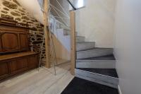 a staircase in a room with a stone wall at Le Logis de Mordreuc in Pleudihen