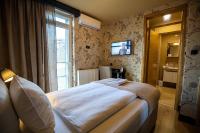 a bedroom with a bed and a tv on the wall at So&sol boutique Hotel, Tuzla in Tuzla