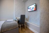 a room with a bed and a desk with a television on the wall at So&sol boutique Hotel, Tuzla in Tuzla