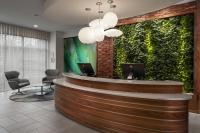 un vestíbulo con una recepción con una pared verde en EVEN Hotel Alpharetta - Avalon Area by IHG, en Alpharetta