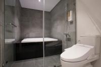 a bathroom with a toilet and a glass shower at P&amp;F Hotel in Taichung