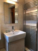 a bathroom with a white sink and a mirror at East Crinnis Log Cabin in Par