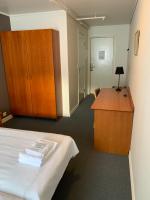 Habitación con cama, escritorio y armarios. en Narvik Budget Rooms, en Narvik