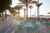 a row of chairs and tables on the beach at Occidental Sharjah Grand in Sharjah