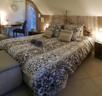 a bedroom with a bed with a black and white comforter at La Villa Esterel &amp; SPA in Village-Neuf