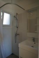 a white bathroom with a shower and a sink at Résidence Les Castors in Calvi