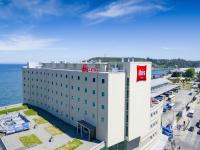 un hotel con una señal roja en la parte superior de un edificio en ibis Puerto Montt, en Puerto Montt