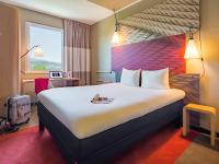 a hotel room with a large bed and a window at ibis Baden Neuenhof in Baden