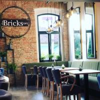 a dining room with tables and chairs and windows at Apartament The Bricks 1903 in Bistriţa