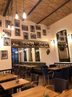 a restaurant with wooden tables and chairs and mirrors at Apartament The Bricks 1903 in Bistriţa